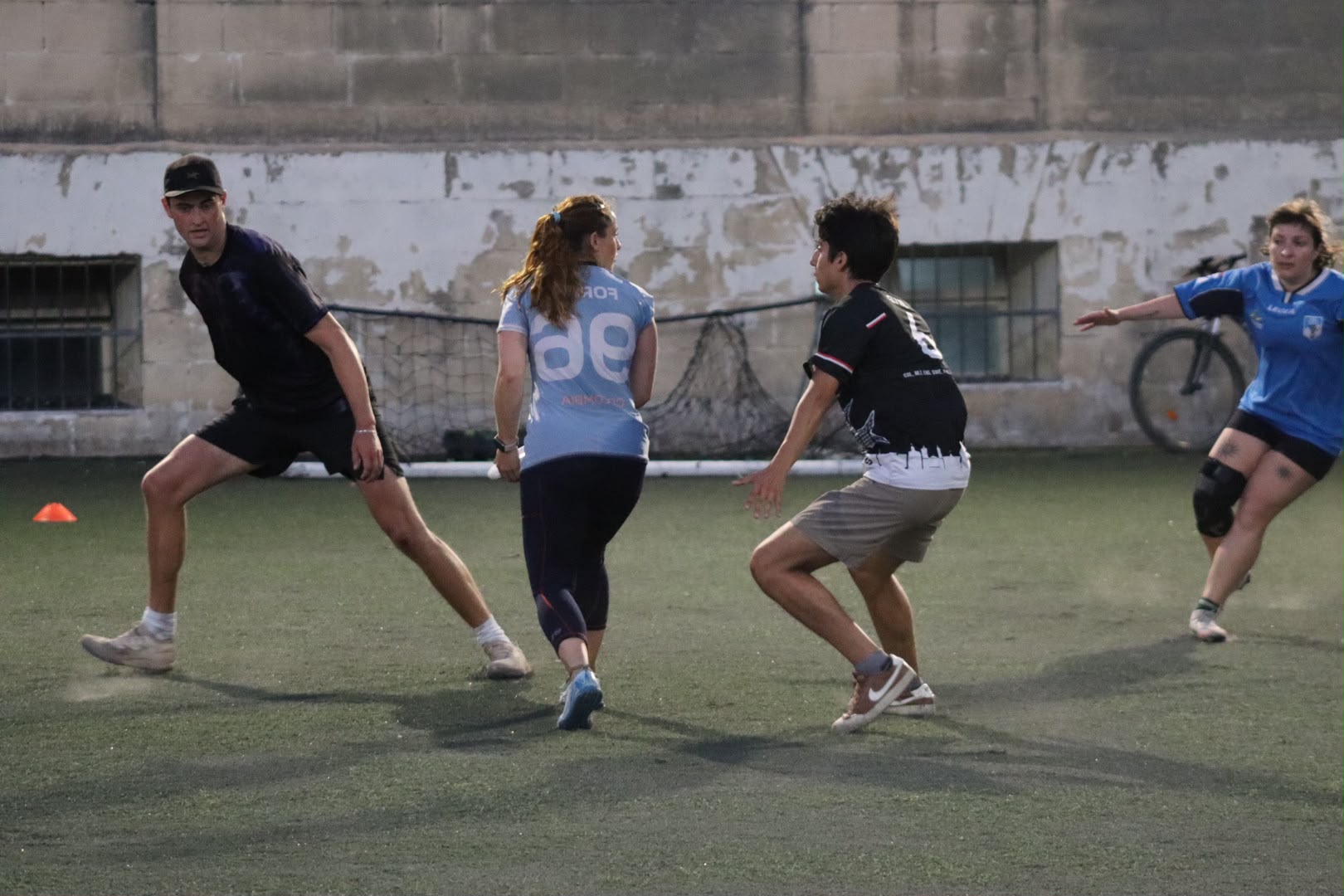 Four players cutting and defending during a mixed training game in Attard