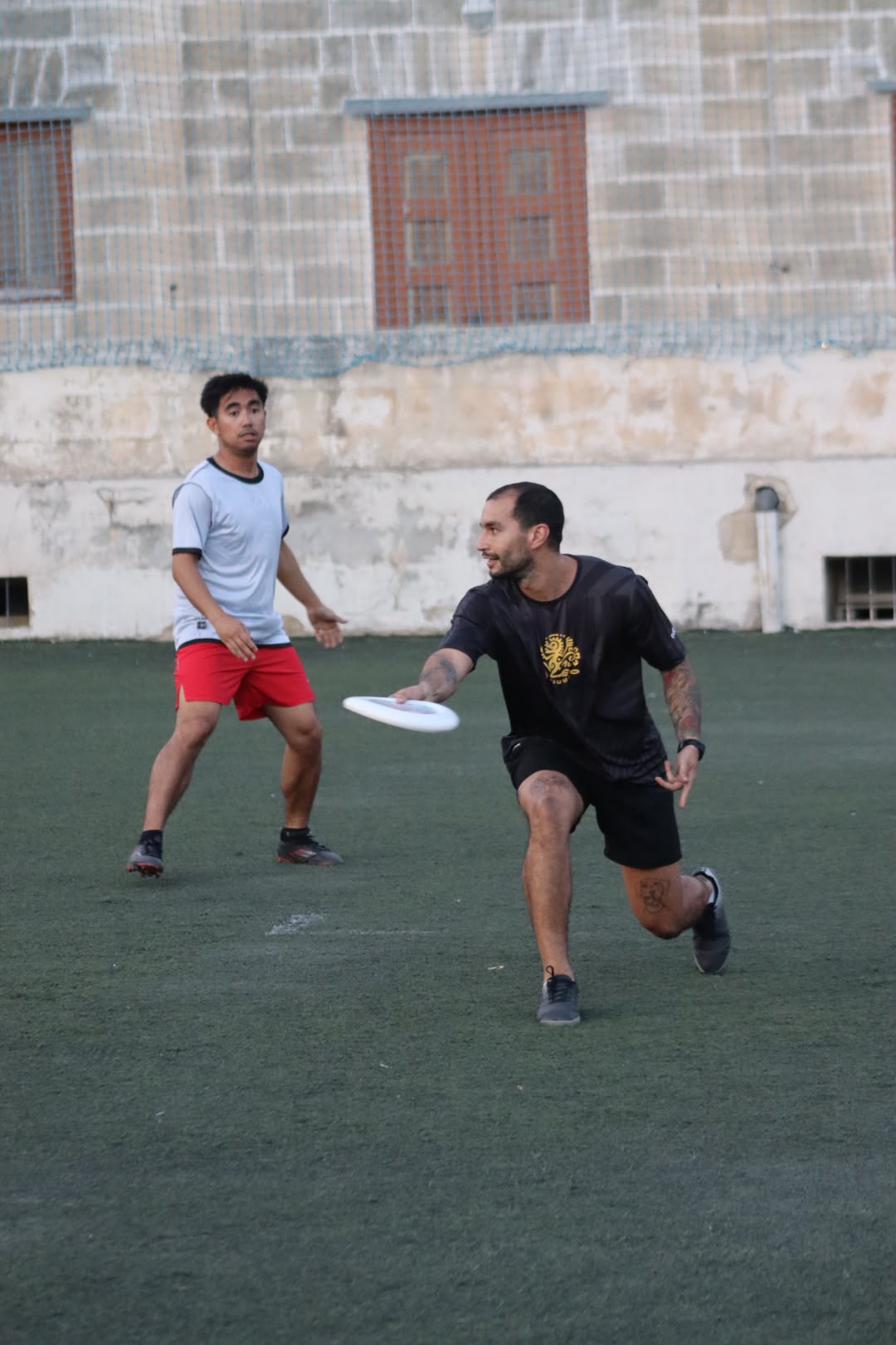 A player catching the disc on the run with a defender closing in